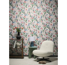Vue d'une pièce avec papier peint à motifs floraux, fauteuil et table d'appoint