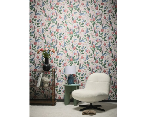 Vue d'une pièce avec papier peint à motifs floraux, fauteuil et table d'appoint