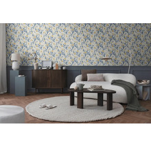 Salon avec papier peint à motifs floraux, canapé et table en bois