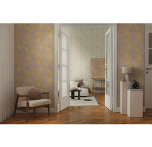 Salon lumineux avec papier peint à motifs, fauteuil et plancher en bois