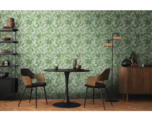 Salon avec table à manger, chaises, étagère, armoire et papier peint à motifs végétaux.