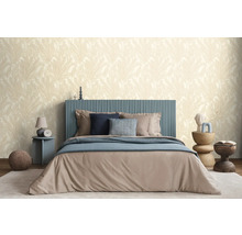 Une chambre avec un lit, des tables de chevet et un papier peint à motifs.