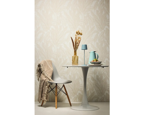 Table de salle à manger décorative avec chaise, lampe de table et accessoires devant un papier peint à motifs