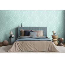 Chambre avec lit, tables de chevet et papier peint à motifs de feuilles pour une ambiance relaxante.