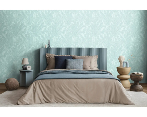 Chambre avec lit, tables de chevet et papier peint à motifs de feuilles pour une ambiance relaxante.