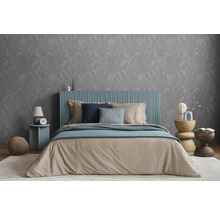 Schlafzimmer mit Doppelbett, Nachttisch und gemusterter Tapete für eine ruhige Atmosphäre.