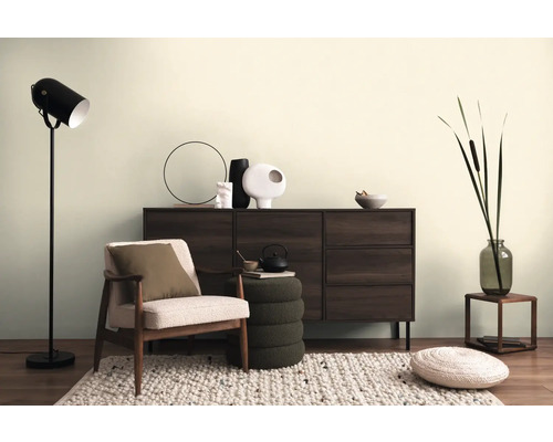 Wohnzimmer mit Sessel, Kommode, Stehlampe und dekorativen Accessoires für ein gemütliches Ambiente