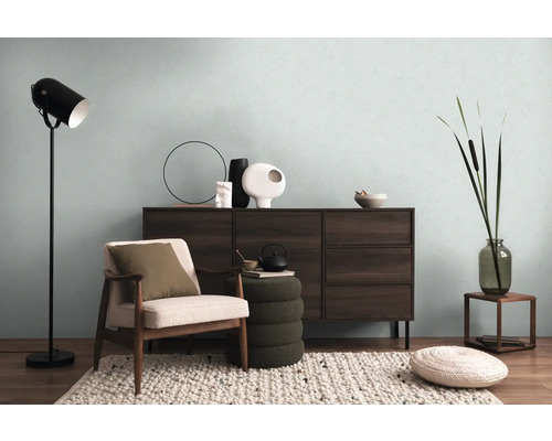 Salon avec commode, fauteuil, lampadaire et éléments décoratifs pour une ambiance chaleureuse