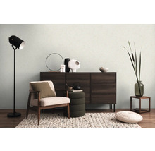 Salon avec fauteuil, commode, lampadaire et décorations pour une ambiance chaleureuse.