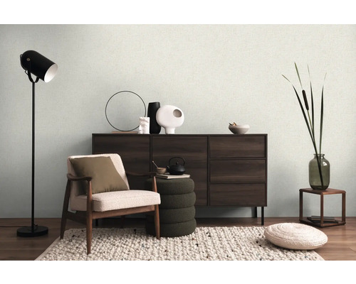 Salon avec fauteuil, commode, lampadaire et décorations pour une ambiance chaleureuse.