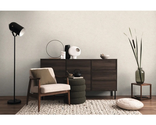 Intérieur avec fauteuil, lampadaire, commode et éléments décoratifs pour une ambiance chaleureuse.