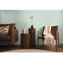 Wohnzimmer mit Sofa, Stuhl und Beistelltischen in hellem Ambiente