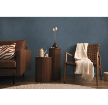 Salon avec canapé, fauteuil, tables d'appoint et décoration sur papier peint bleu texturé