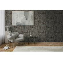 Salon avec fauteuil, table et décoration devant un mur structuré