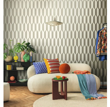 Wohnzimmer mit geometrischer Tapete, Sofa, Beistelltisch und dekorativen Elementen für ein stilvolles Ambiente.