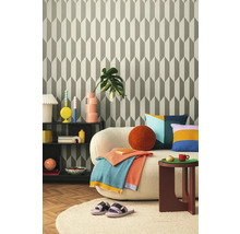 Wohnzimmer mit gemusterter Tapete, Sofa, Beistelltisch und Dekorationen für ein gemütliches Ambiente.