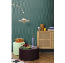 Intérieur avec un mur décoratif, une lampe, une commode et des éléments décoratifs pour une ambiance élégante.