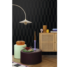 Mobilier dans une pièce avec papier peint à motifs géométriques, lampadaire et armoire en bois