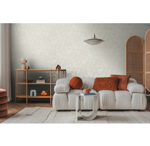 Salon lumineux avec papier peint à motifs, canapé, tapis et étagère en bois