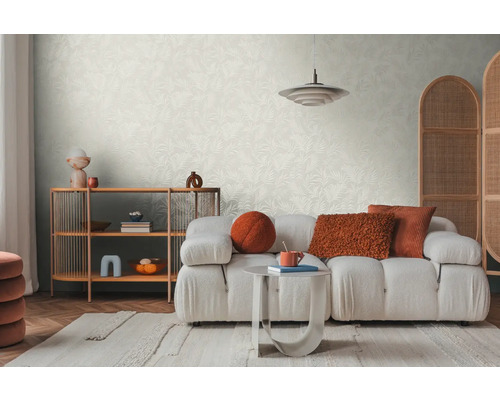 Salon lumineux avec papier peint à motifs, canapé, tapis et étagère en bois