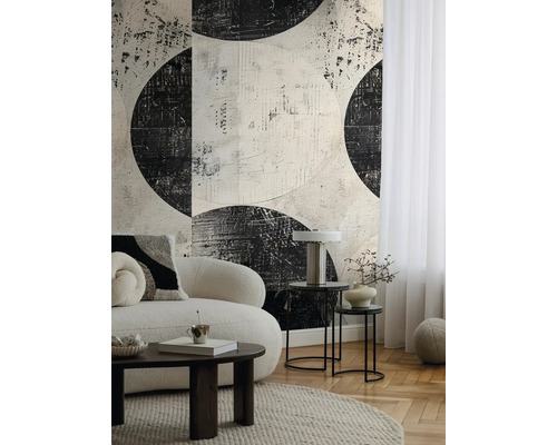 Salon avec canapé, table basse et papier peint à motif de cercles abstraits.