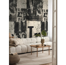 Salon avec canapé, table en bois et papier peint avec motif de journal