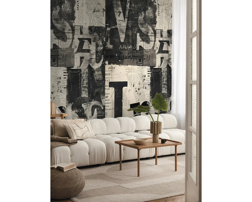 Salon avec canapé, table en bois et papier peint avec motif de journal
