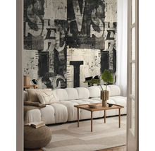 Salon avec canapé, table en bois, tapis et papier peint à motifs de journaux