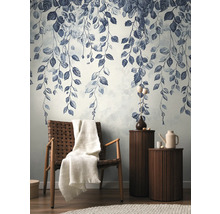 Papier peint décoratif avec motif de feuilles dans un salon élégant avec fauteuil et tables d'appoint.