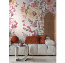 Salon avec canapé, table, coussins et papier peint floral pour une ambiance chaleureuse