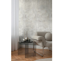 Intérieur avec papier peint imitation béton, fauteuil et table d'appoint