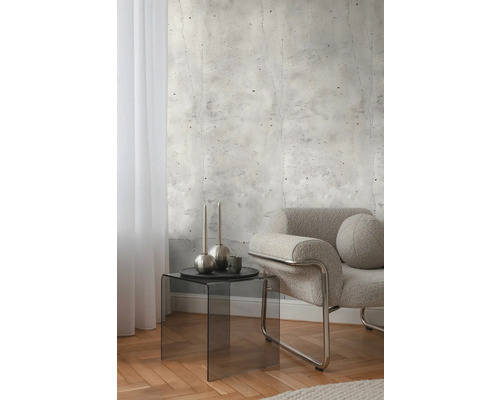 Intérieur avec papier peint imitation béton, fauteuil et table d'appoint