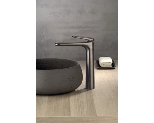 Waschtischarmatur neben einem Aufsatzwaschbecken auf einer Holzoberfläche