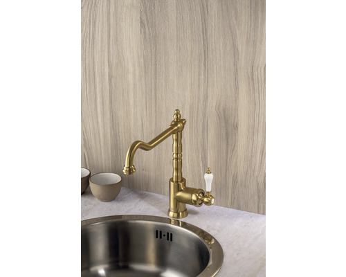 Küchenarmatur aus Messing mit weißem Griff neben einer Spüle