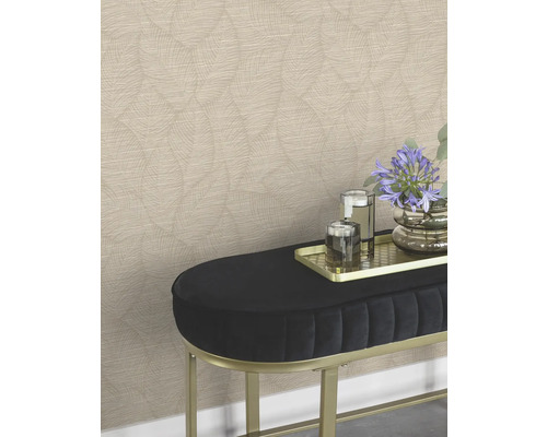 Un mur avec du papier peint à motifs derrière un banc avec des fleurs et des verres