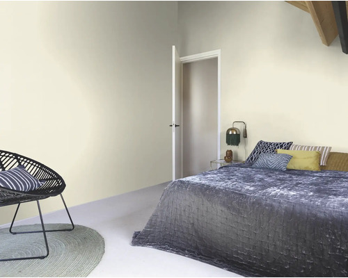 Helles Schlafzimmer mit Bett, Sessel und Tür