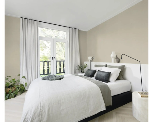 Helles Schlafzimmer mit Bett, Nachttischen und Vorhängen vor einer Balkontür