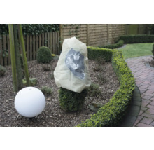 Scène de jardin avec housse de protection pour plantes et luminaire de jardin