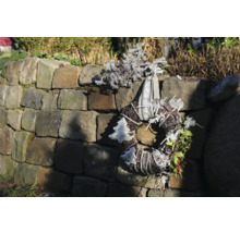 Couronne de l'Avent décorative avec ruban et motifs de Noël sur un mur de pierre