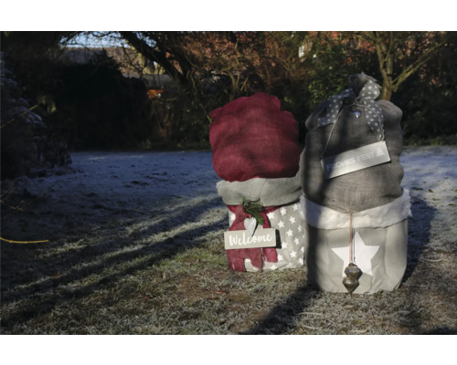 Figurines décoratives en tissu dans le jardin avec les inscriptions Bienvenue et Joyeuses Fêtes.