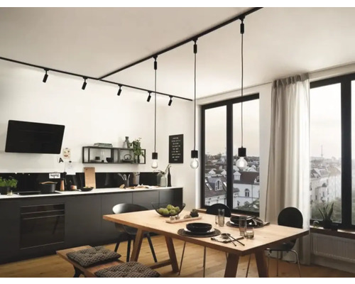 Cuisine moderne avec kitchenette noire, table à manger et système de rails avec spots et suspensions