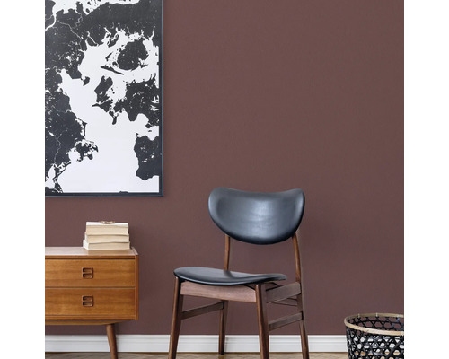 Wohnzimmer mit Kommode, Stuhl und Weltkarte an der Wand