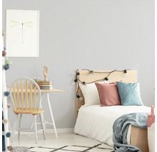 Helles Schlafzimmer mit Schreibtisch, Stuhl und Bett.