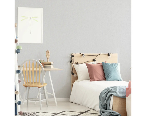 Chambre claire avec bureau, chaise et lit.