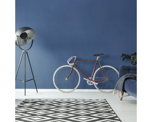 Salon avec lampadaire, vélo et tapis au design graphique
