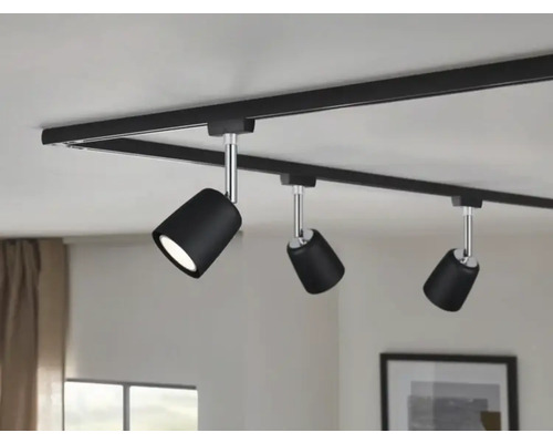 Système de rails noir avec trois spots au plafond.