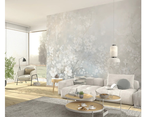Heller Wohnraum mit Couch, Couchtischen und floraler Fototapete
