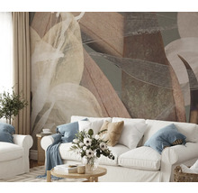 Wohnzimmer mit abstraktem Blättermuster an der Wand hinter einem weißen Sofa.