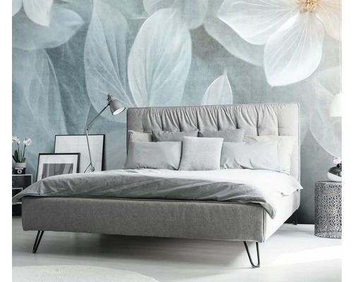 Schlafzimmer mit Bett, Nachttisch und dekorativer Blumendarstellung an der Wand.