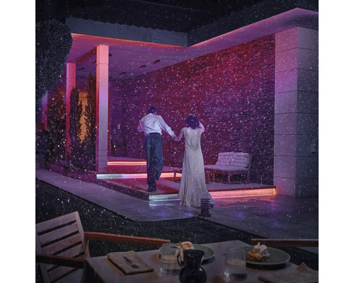 Terrasse illuminée avec couple dans la neige, ambiance élégante pour espaces extérieurs